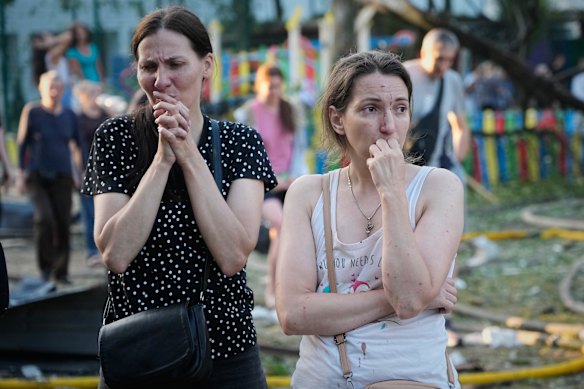 People react at the site of a Russian missile strike that hit a residential building in Kyiv.