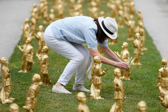 A woman takes pictures of 400 gold colored plastic Mozart sculptures by German artist Ottmar Hoerl from Nuremberg before the 270th birthday of composer Wolfgang Amadeus Mozart in Salzburg, Austria.
