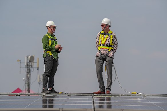 Hijau director Thio Ariyanto and Jonathan Gilbert from the Australian Embassy in  Indonesia inspect an array of rooftop solar panels