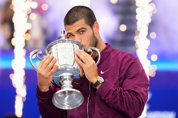 Carlos Alcaraz, of Spain, kisses the championship trophy.