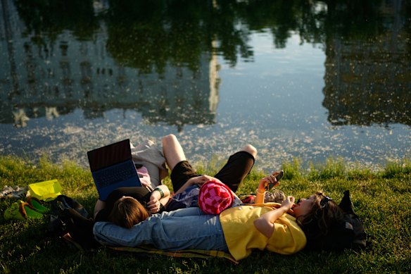 People enjoy the warm weather on a bank of the Clean Ponds in Moscow.