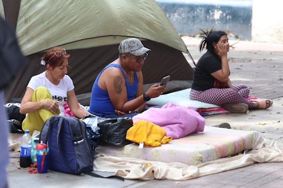 Residents and their belongings on a street in Caracas after twin earthquakes caused major destruction.