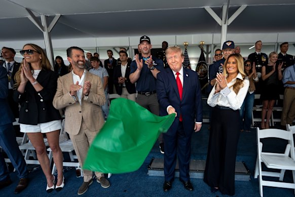 US President Donald Trump waves the green flag to start the IndyCar race alongside first lady Melania Trump. Natalie Harp, second from right, takes a back seat.