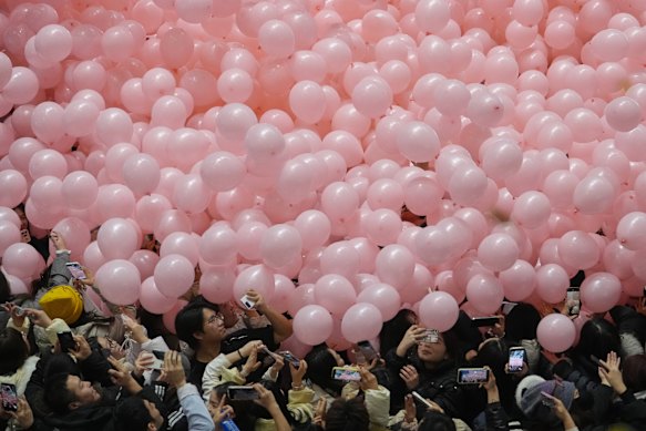 Revellers film falling balloons as they celebrate the countdown in Beijing.