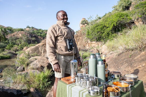 Guide Denzol Thungutho sets up breakfast by the river.