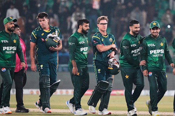 Australia’s Xavier Bartlett, second left, and Adam Zampa, third right, and Pakistani players walk off the field on the end of their T20 cricket match in Lahore, Pakistan.