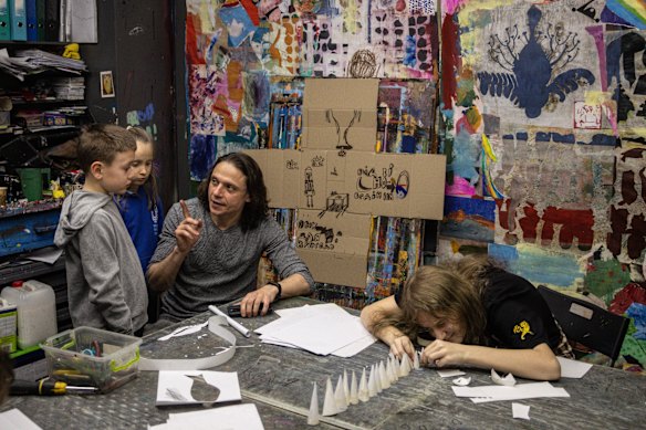 Children listen on as founder of Aza Nizi Maza, an underground art space teaching art to children Mykola Kolomiets speaks about sculpture in Kharkiv, Ukraine. Aza Nizi Maza, originally an underground bomb shelter was converted into an art space in 2012, after Russia’s full-scale invasion began it once again became a shelter for residents and children.
