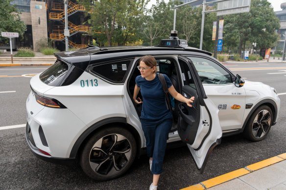 North Asia correspondent Lisa Visentin walks out of robotaxi in south Beijing.