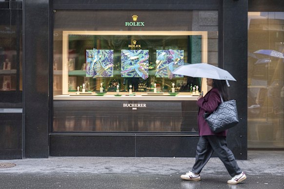 A woman walks by a store selling Rolex watches in Lucerne, Switzerland.