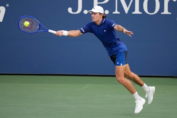 De Minaur stretches for a forehand. 