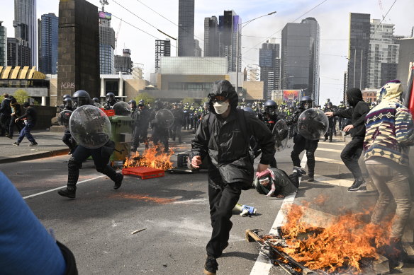 Masked protesters clash with police during a demonstration against the Land Forces expo in Melbourne in September.