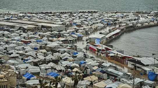 A tent camp for displaced Palestinians stretches across the Gaza City seaport.