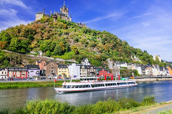 A Rhine river ship sails by the scenic medieval German town of Cochem.