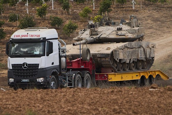 A truck carries a military tank from inside the Gaza Strip in southern Israel  following the announcement that Israel and Hamas have agreed to the first phase of a peace plan to pause the fighting.