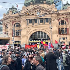 Crowds gather in the Flinders Street intersection for the dual anti-racism protests.