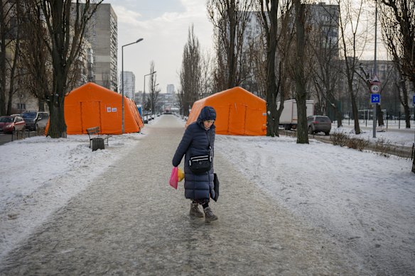 A woman walks by emergency heating points set up in a Kyiv neighbourhood.