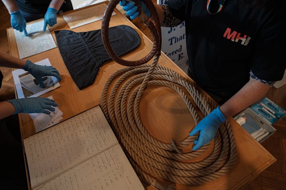 Staff from Museums of History NSW with a noose and black hood used in the execution of convicted poisoner Louisa Collins in 1889. 