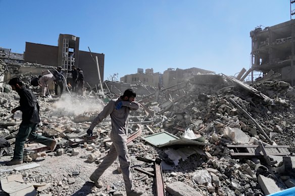 A group of men inspects the ruins of a police station in Tehran.