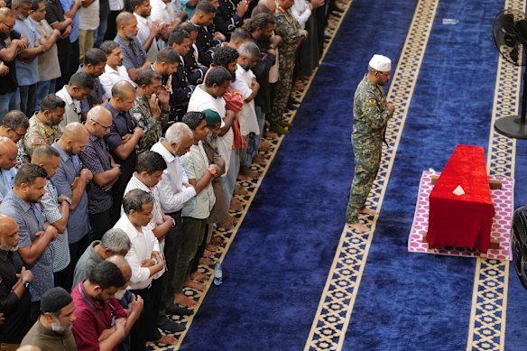 Maldivian President Mohamed Muizzu and National Defence Force members pray in front of the remains of military diver Mohamed Mahudhee, who died during the search operation.