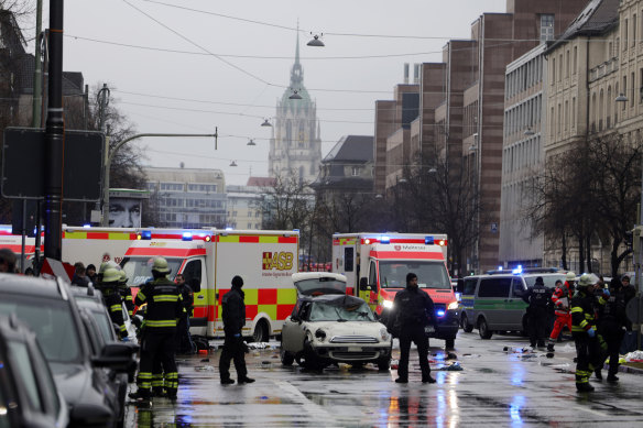 Police and emergency services stand near a damaged car that apparently drove into demonstrators marching in the city centre in Munich, Germany.