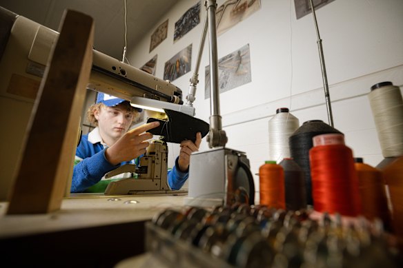 Arlo performs upper stitching as he learns to make sneakers.