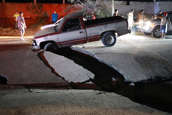 A vehicle is trapped in a fissure caused by an earthquake in La Guaira, Venezuela.