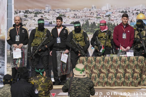 Hostages (from left) Iair Horn, Sagui Dekel Chen and Alexander Troufanov are taken by Hamas and Islamic Jihad fighters to be handed over to the Red Cross in Khan Younis in the Gaza Strip.