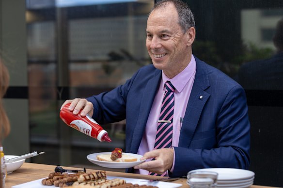 Jeff Pope serves The Age democracy sausages at AEC building in Melbourne.
