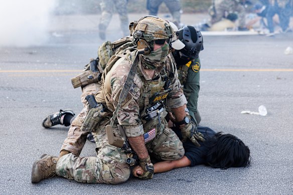 Federal officers hold down a protester in Chicago after protesters learnt that US Border Patrol agent had shot a woman on Saturday morning in Chicago.
