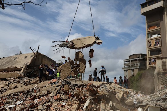 People and rescuers work on the debris from the Moises building in Caracas.