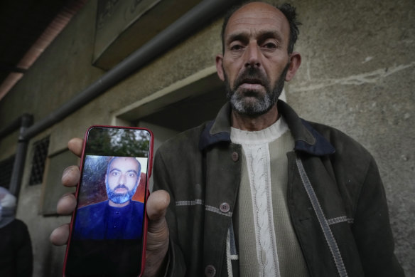 Abou Ahmad holds a picture of his son, who went missing while imprisoned by the late Syrian government, as he searches for his body at the al-Mojtahed hospital morgue in Damascus on Wednesday. 