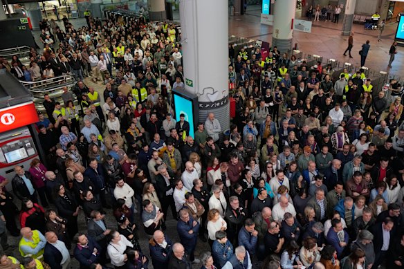 At Atocha railway station in Madrid on Thursday, commuters observe a minute of silence for the victims of the train crash.