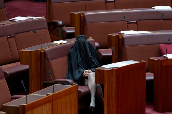 Senator Pauline Hanson sits in her seat after entering the chamber.