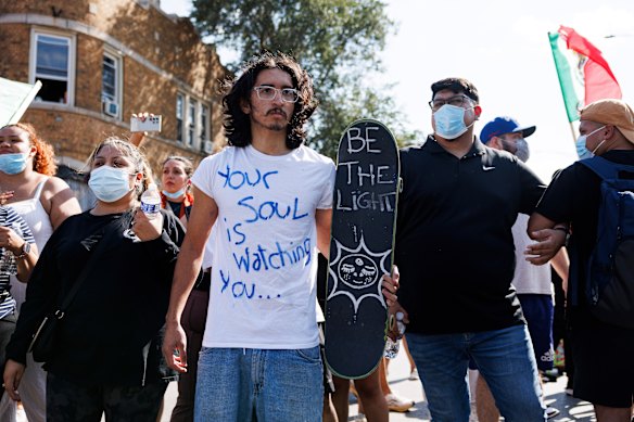 Protesters stand and chant in the Brighton Park neighbourhood of Chicago on Saturday.