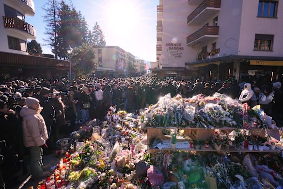 People gather to remember the fire victims in Crans-Montana on Sunday.