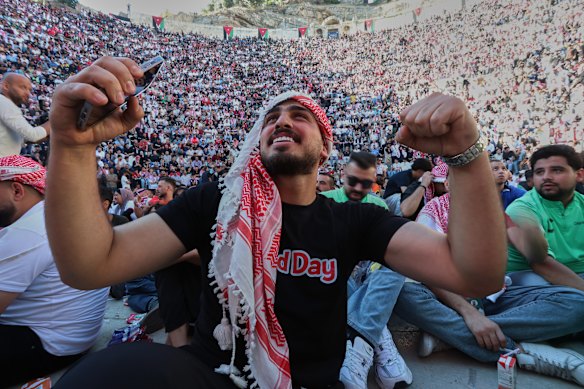 A Jordanian soccer fan reacts while watching the World Cup match between Jordan and Austria on a large screen at the Roman Amphitheater in downtown Amman, Jordan.