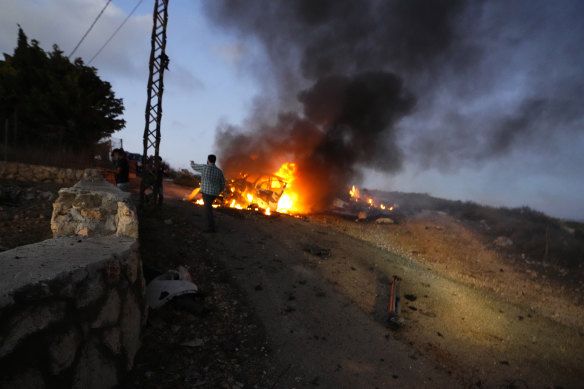 A journalist’s car burns after it was hit by Israeli shelling in the Alma al-Shaab border village with Israel, south Lebanon.