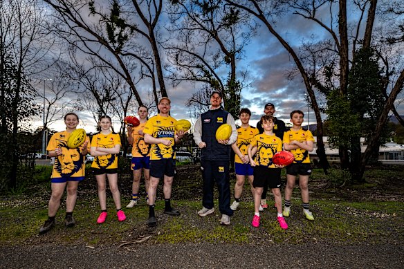 Members of Harcourt Football and Netball Club in the recovering bush at the edge of their oval. From left: Harper, Bonnie, Cohen, senior coach Sam Gale, captain Tom Walters, Austin, Judd, Joel and Raf.