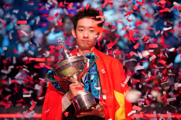 China’s Wu Yize poses for the media with the trophy and wearing the Chinese national flag, after winning the World Snooker Championship. 