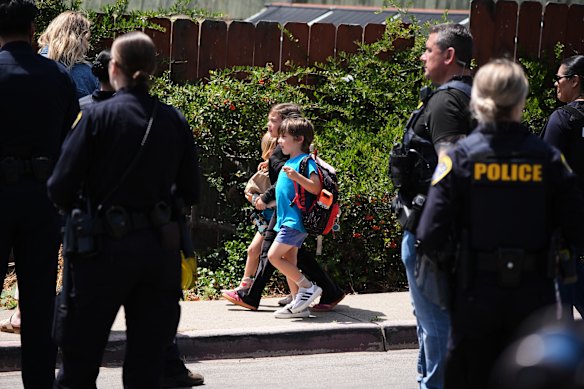 Children hold hand as they walk near the scene of the shooting.