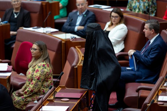Senator Pauline Hanson moves to the other side of the Senate chamber during a vote. Members of the Greens and crossbench were furious with the stunt.