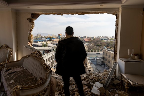 A man stands in a damaged residence at the site of buildings, including a police station, that were destroyed in an airstrike two days ago in the Khani Abad neighbourhood of Tehran, Iran.