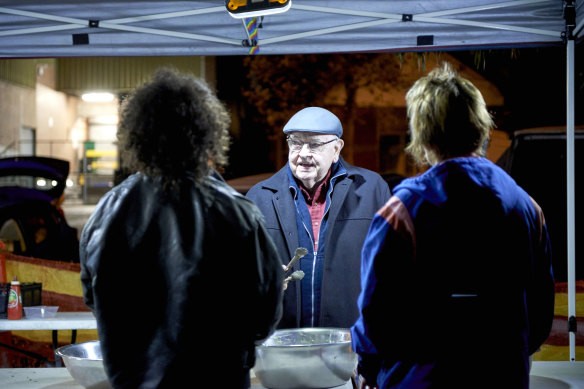 Father Bob Maguire wields the tongs at a community meal in St Kilda.