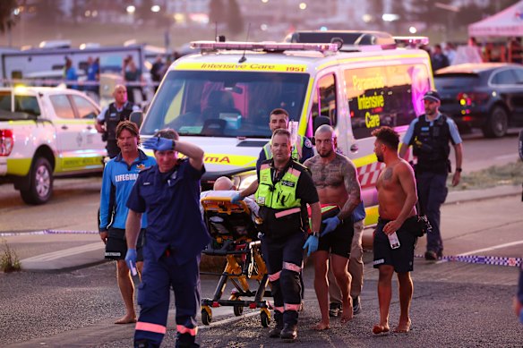 Paramedics rush a victim to an ambulance.