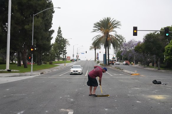 Jovani Van cleans up the streets in Paramount, California on Sunday morning following a protest against immigration raids.