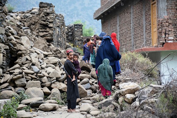 Residents in Mazar Dara walk past a destroyed house on Monday. A New York Times journalist who arrived in the area the day after the quake didn’t see any women among the medical, rescue or aid teams treating victims.
