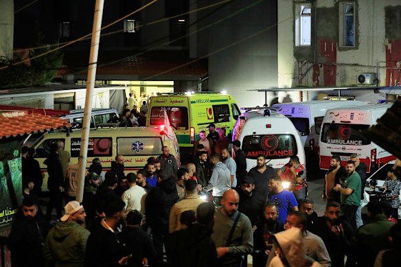 People gather near ambulances ferrying victims of the strike at Ein el-Hilweh refugee camp in Sidon.