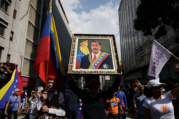 A man holds a portrait of Maduro during a protest in Caracas.