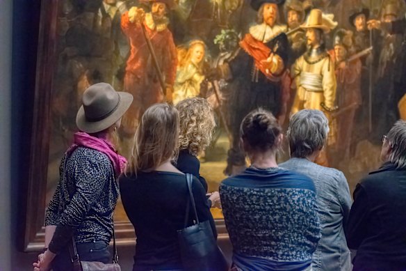 Viewers work up an appetite with Rembrandt’s The Night Watch at the Rijksmuseum, Amsterdam.