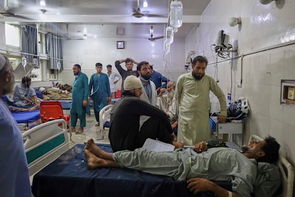 Injured Afghan men wait to be treated at a hospital in Jalalabad on Tuesday.